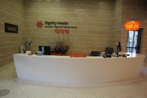 A branded “Hello” desk immediately greets patients and visitors upon entering the lobby from the exterior.