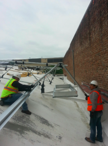 Installers work on the framing system to support solar panels.
